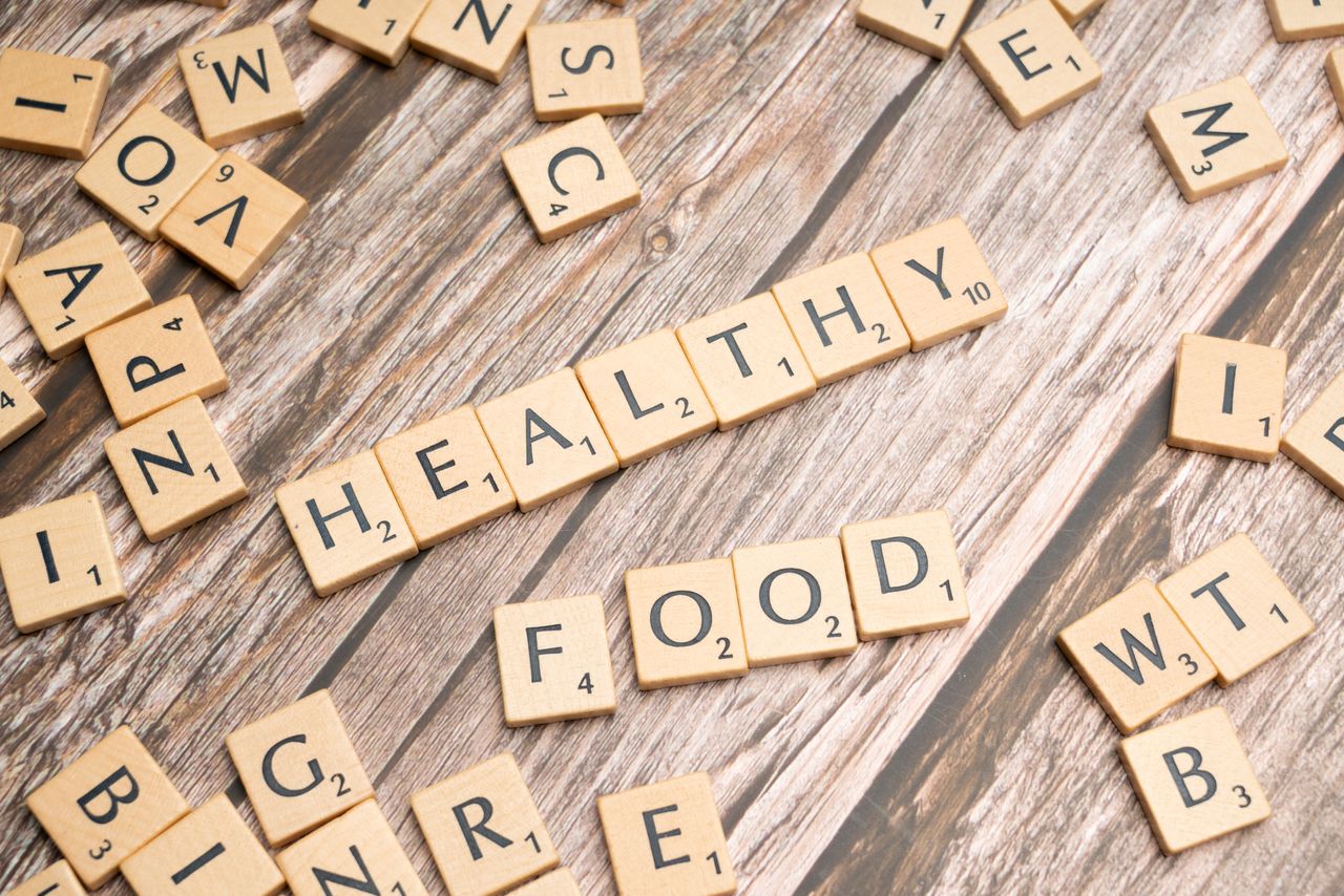 who-we-are Wooden tiles spelling 'healthy food' on a wooden background creating a natural and organic theme.